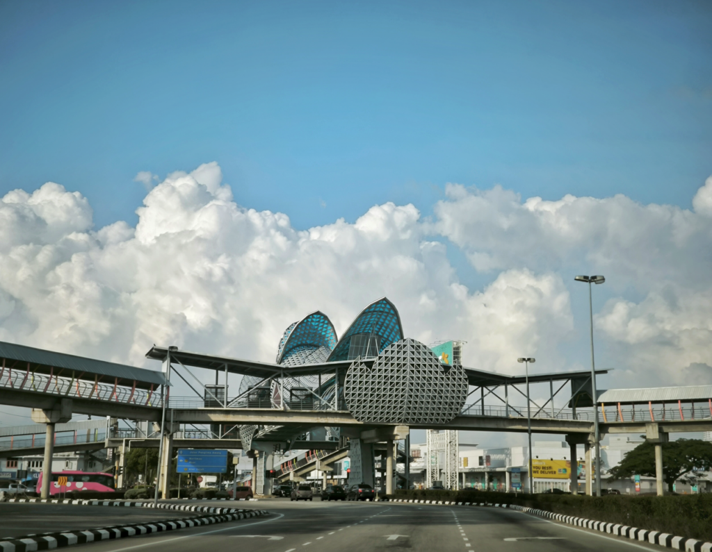 Contemporary pedestrian bridge and architecture under a bright blue sky with clouds.